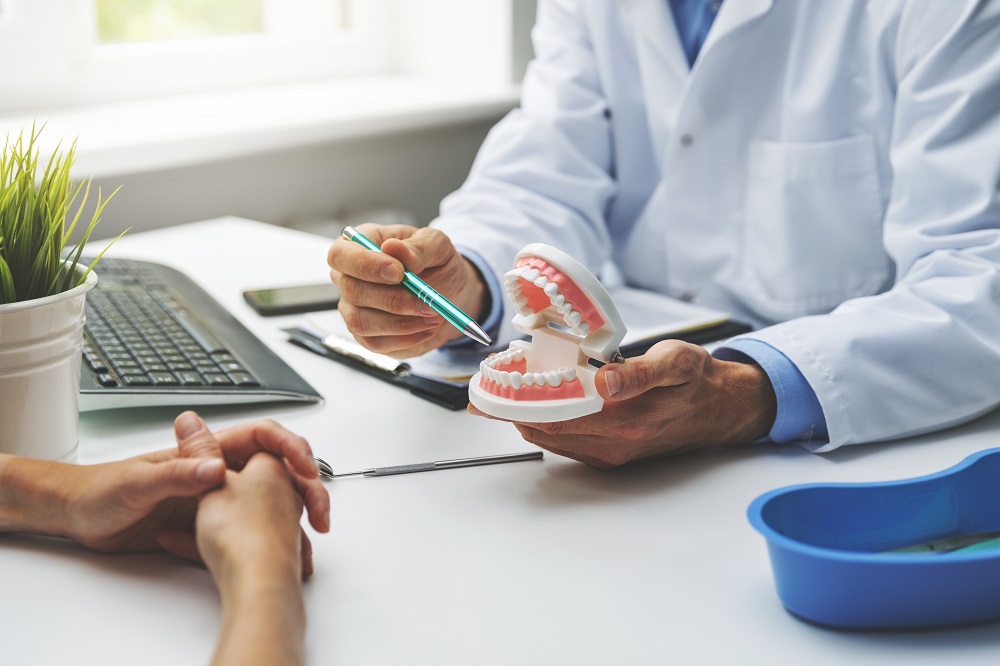 dentist and patient discussion about planned teeth treatment in dental clinic office